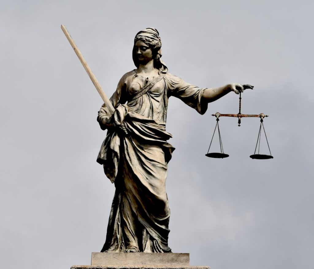 A statue of Lady Justice holding a sword and scales — illustrating a Singapore rioting sentencing case study