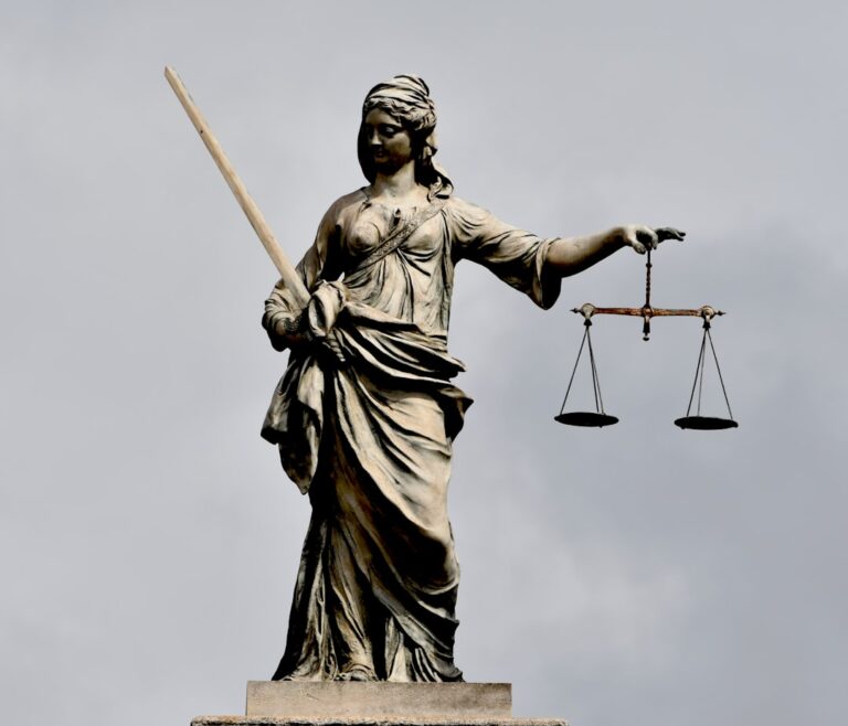 A statue of Lady Justice holding a sword and scales — illustrating a Singapore rioting sentencing case study
